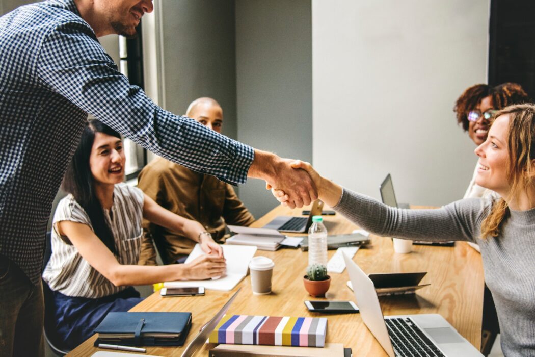 Two workers shaking hands in a meeting